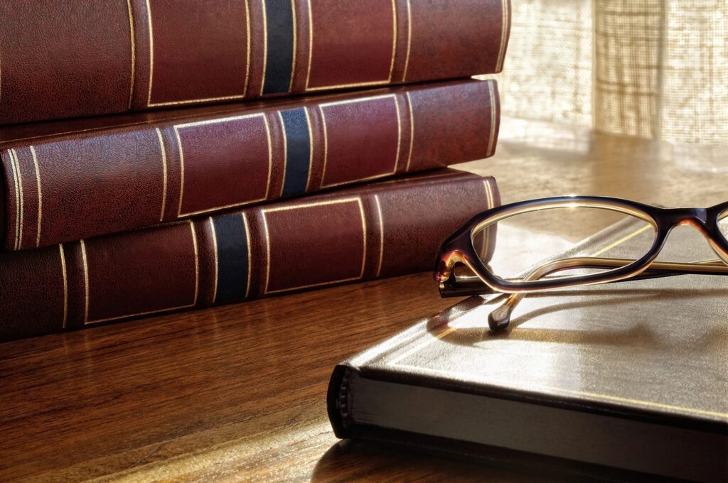 Books and eye glasses  laying on a table.