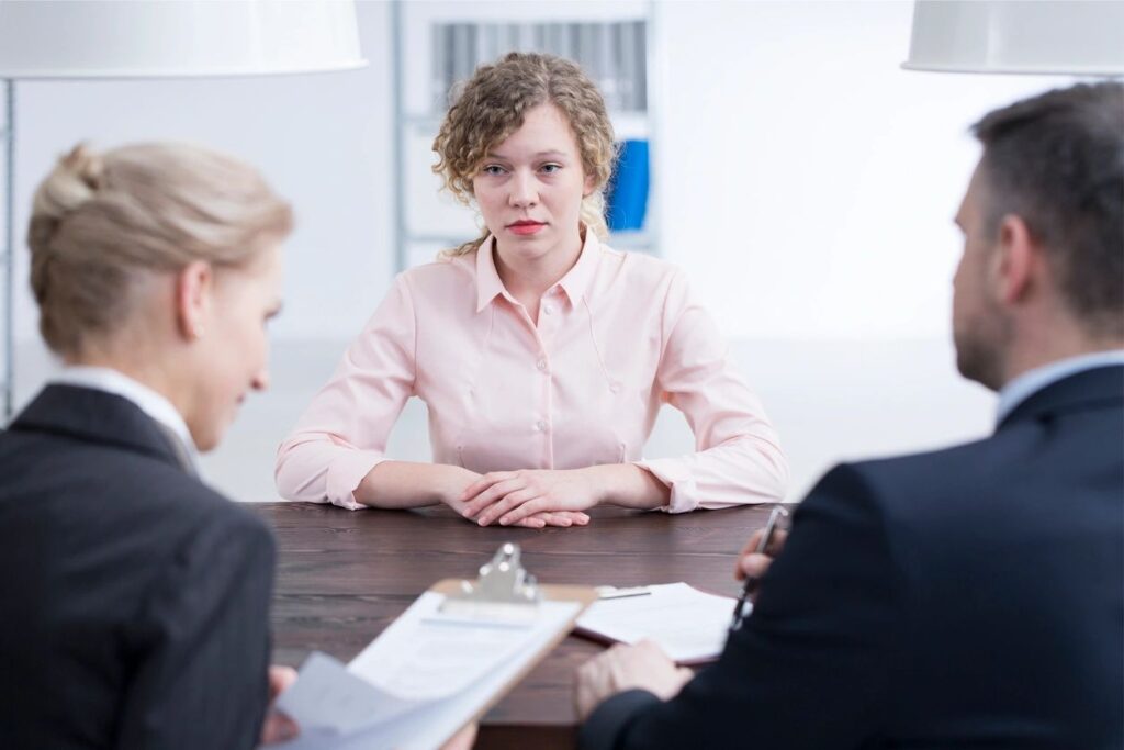 Three people seated around a conference table.